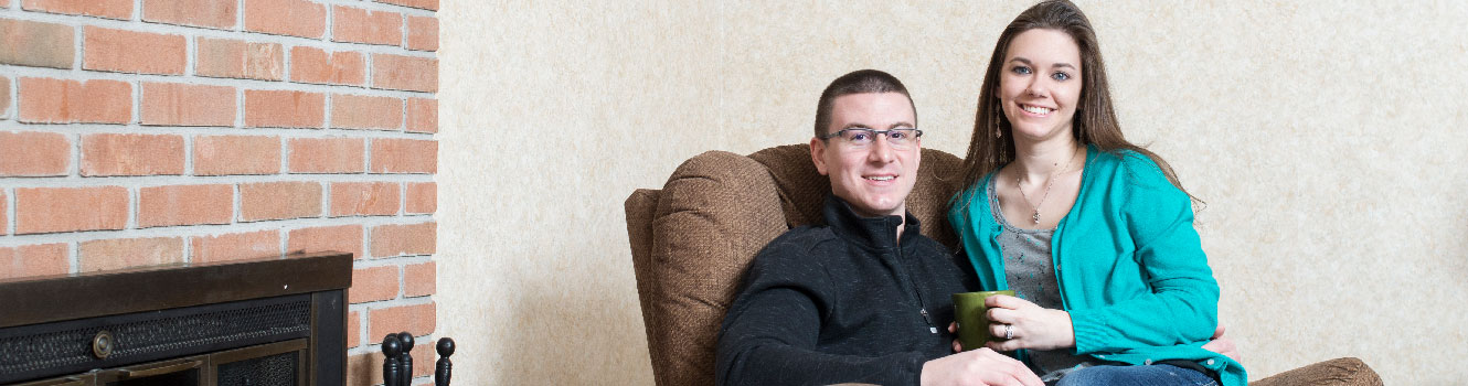 Couple in living room sitting together in easy chair