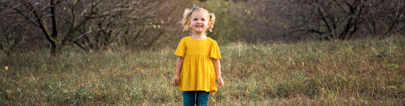 Little girl in field with a big smile